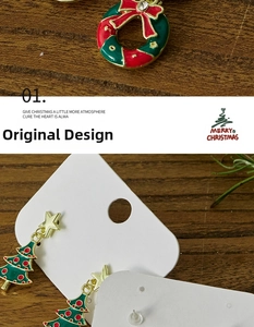 Detailed view of enamel Christmas wreath and tree stud earrings on wood texture