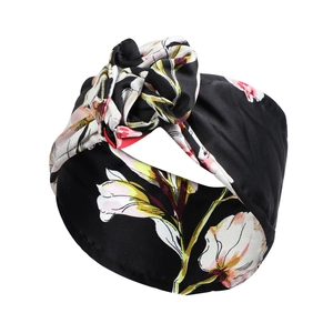 Detail eines schwarzen geblümten Samt-Stirnbands mit eleganten großen Blumenmustern