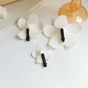 Three-piece set of white plumeria flower clips in different sizes with metal duckbill back