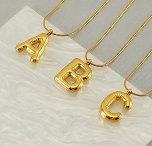 Detail of 3D bubble balloon alphabet necklaces A, B, C with polished gold snake chains