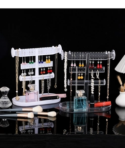 Detail of multi-tier jewelry organizer with hooks and tray in white and clear finish