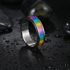 Macro shot of silver stainless steel rainbow ring with water drops on black surface