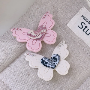 Detail shot of butterfly hair clips with sparkling rhinestones and marble heart pattern