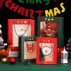 Close-up of Christmas gift bags with transparent window and cartoon Santa deer prints