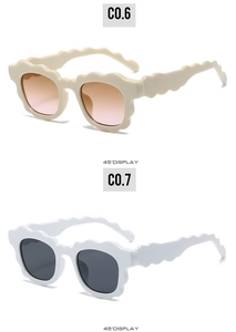 Detail view of wavy frame sunglasses in cream and white finishes with gradient lenses