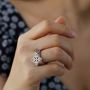 Silver stainless steel ring featuring a dangling Celtic Witch's Knot charm on hand
