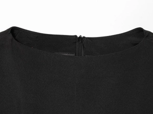 Gros plan du col rond et de la fermeture éclair invisible sur cette robe courte noire