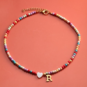 Detailansicht der bunten Perlenkette mit Herzanhänger und goldenem Buchstaben R Anhänger