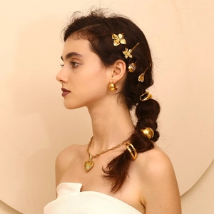 Detail showing 18K gold plated eggshell hair clips and heart pendant necklace on model
