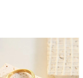 Close-up of a gold chunky chain heart necklace on a natural stone background