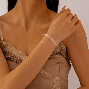Close-up of minimalist transparent acrylic geometric round bangle worn on the wrist