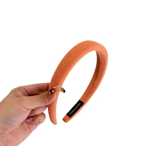 Serre-tête rembourré en sergé orange saumon avec étiquette faite main et texture tricotée