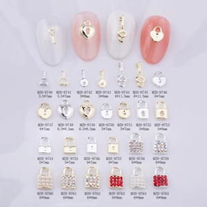 Vue détaillée de bijoux d'ongles en métal avec motifs de serrure et clé sertis de perles