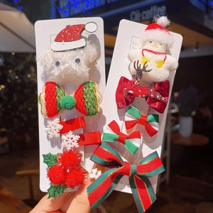 Detailed view of Christmas hair clips featuring plush Santa, reindeer bows, and pom-poms