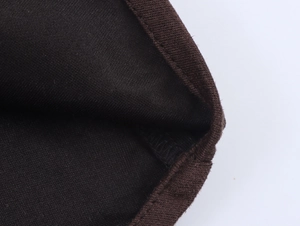 Gros plan sur la texture en tricot marron et la doublure noire du revers du vêtement