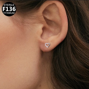 F136 titanium heart-shaped ear piercing with sparkling zircon stones on human ear