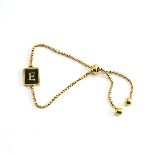 Detailed macro view of 18K gold plated square pendant with initial E on adjustable chain