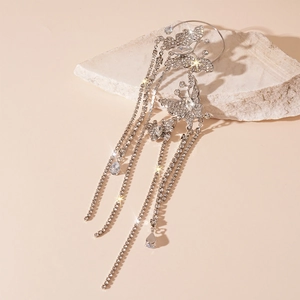 Detailed view of silver butterfly ear cuff with sparkling zircon tassels on a stone