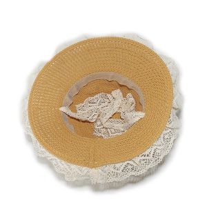Detailed top view of a khaki straw hat with wide white crochet lace edges and inner ribbon