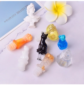 Artistic layout of DIY resin wine bottle stoppers in cat and crown shapes on marble