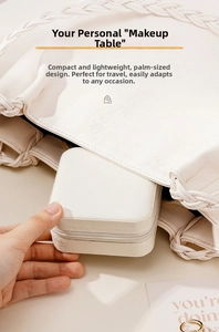 Portable white leather jewelry box being placed into a bag for travel storage