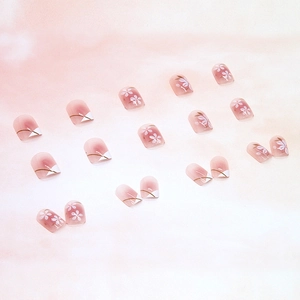 Pink gradient press-on nails with white cherry blossoms and delicate gold line accents