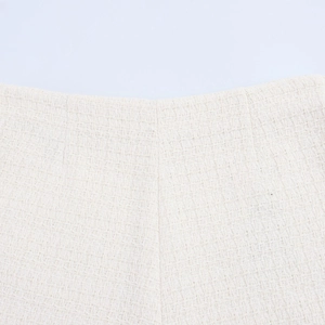 Macro shot of cream tweed fabric texture and waist stitching on the two-piece skirt set