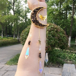 Detail of golden moon and butterfly suncatcher with crystals and prisms in natural light
