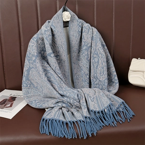 Detailed macro view of blue paisley scarf with soft fabric texture and fringe tassels