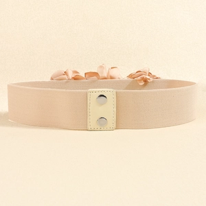 Detailed view of beige elastic belt with fabric rose and silver metal snap closure buttons