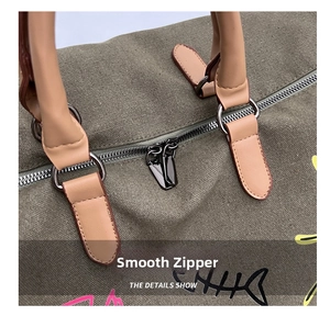 Detail of smooth silver metal zipper and brown leather handle on green travel duffel bag