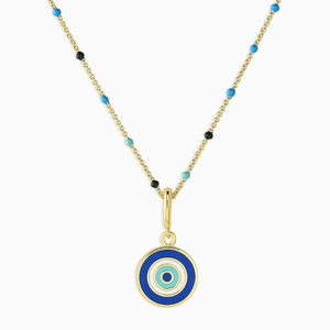 Close-up of golden chain necklace with colorful enamel beads and devil eye coin pendant