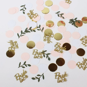 Detail of Bride to Be confetti set with gold glitter text and green leaf shapes
