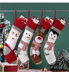 Macro detail of knitted Christmas stockings featuring Santa, snowman, and reindeer designs