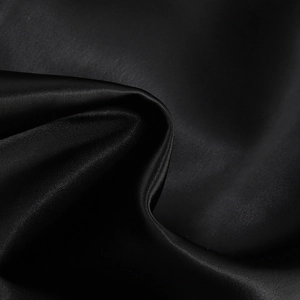 Gros plan détaillé montrant la texture lisse et les plis élégants du tissu en satin noir