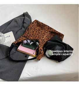 Detail view of large leopard print tote bag interior with tablet and cosmetics
