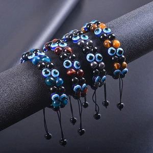 Detail of multi-color Evil Eye beaded bracelets with natural stones on a black display
