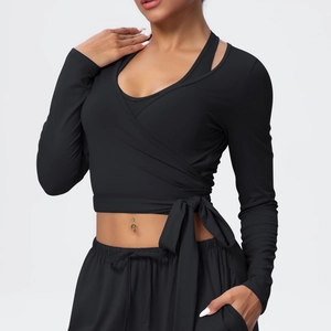 Detail of black V-neck wrap yoga top with cross tie-waist and high-stretch athletic fabric