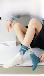 Detail of crew socks in combed cotton featuring blue mountain patterns and text