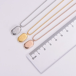 Macro detail of three titanium steel oval pendants in gold, silver, and rose gold finishes