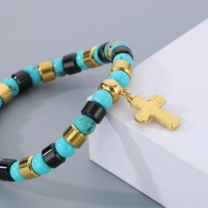 Bracelet bohème en perles de turquoise avec pendentif croix dorée sur socle blanc