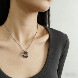 Detail of silver interlocking trinity ring pendant on a delicate steel necklace chain