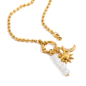 Detail of gold titanium steel necklace with sun and moon charms and freshwater pearls