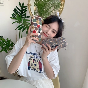 Floral corduroy pencil case and cosmetic bag with merciparis label held by model