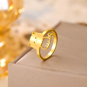 Macro shot of gold cat head and fishbone design on polished metal ring