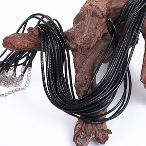 Black waxed cord necklaces with silver lobster clasps on a natural wooden display