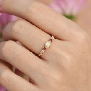 Elegant gold S925 sterling silver ring with opal and colorful gemstones on a finger
