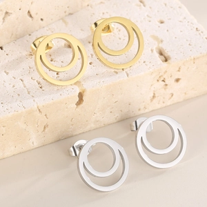 Elegant gold and silver double round zircon stud earring set on a beige stone display
