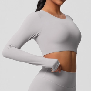 Gros plan du crop top de yoga gris clair à manches longues montrant la coupe ajustée