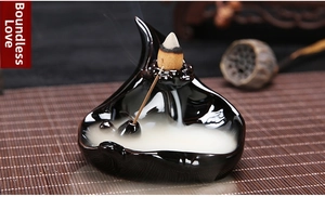 Detail of a black ceramic backflow incense burner showing smoke flowing like a waterfall